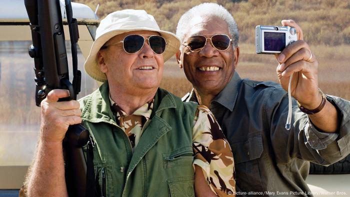 Film still from 'The Bucket List': Jack Nicholson and Morgan Freeman wearing sunglasses and taking a selfie while holding a heavy weapon.