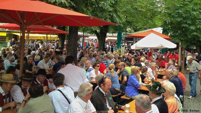 Residents of Munich, Germany, gather in the shade of chestnut trees at the Viktualienmarkt to cool off on a hot summer afternoon