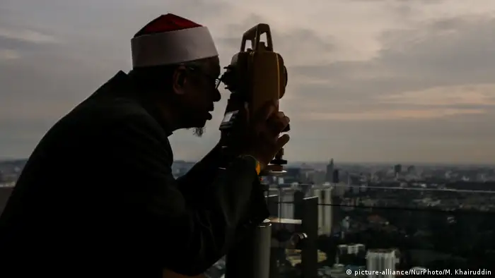 An officer of Malaysia's Islamic authority uses a telescope to catch sight of the new moon of Ramadan (picture-alliance/NurPhoto/M. Khairuddin)
