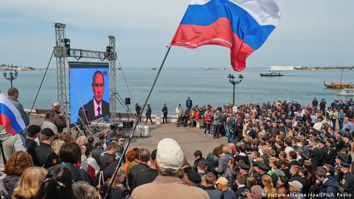 People watch TV address by Vladimir Putin in Crimea