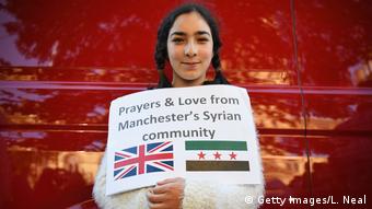 Mädchen mit Schild Gebete und Liebe von Manchesters syrischer Gemeinde