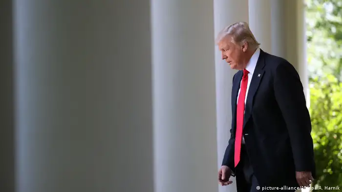 Trump walks between columns of the White House 