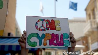 A demonstrator holds up a sign for unification on the divided island of Cyprus