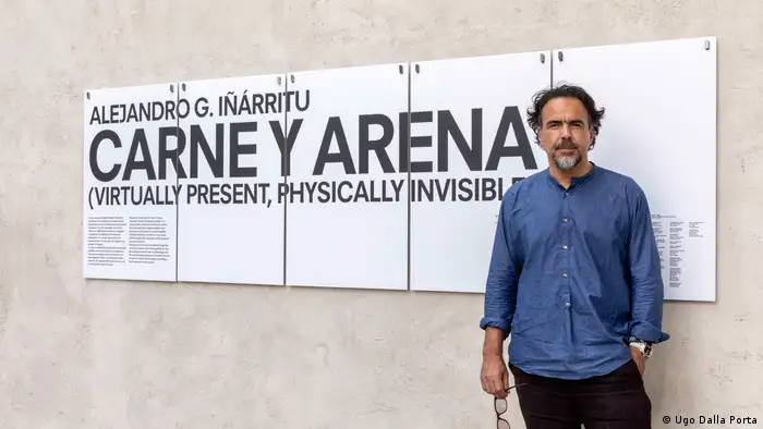 Alejandro G. Inarritu stands in front of a sign advertising his film (Ugo Dalla Porta)