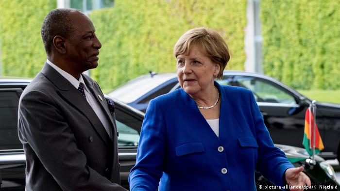 German chancellor Angela Merkel shaking hands with Guinea's president Alpha Conde ahead of the G20 Africa summit last year