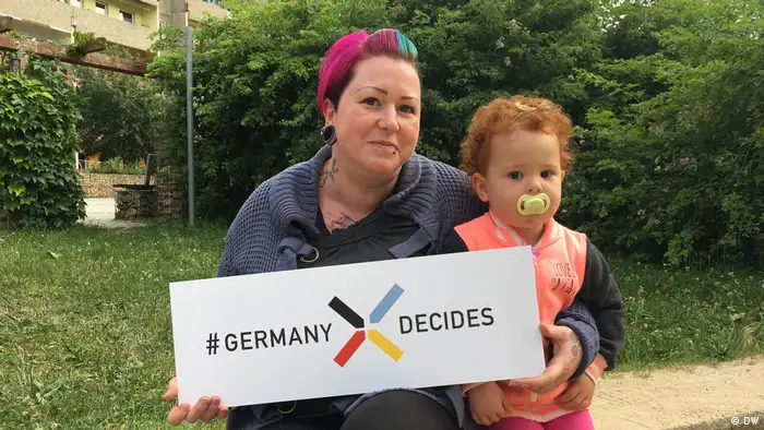 Carmen and her daughter holding a sign that says Germany Decide