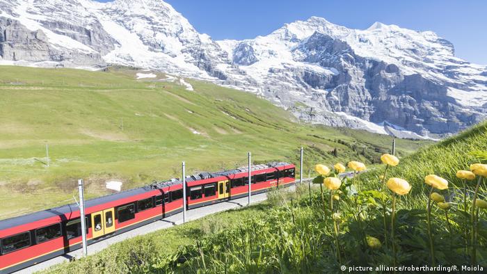 Trem diante de montanha com neve na Suíça