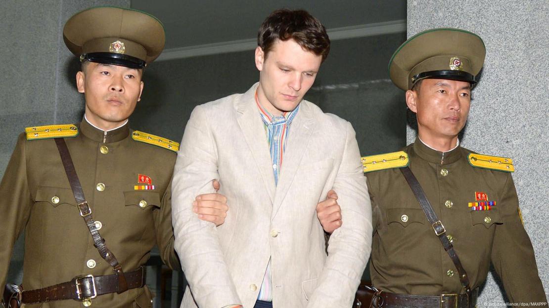 Otto Warmbier sendo levado por dois militares norte-coreanos