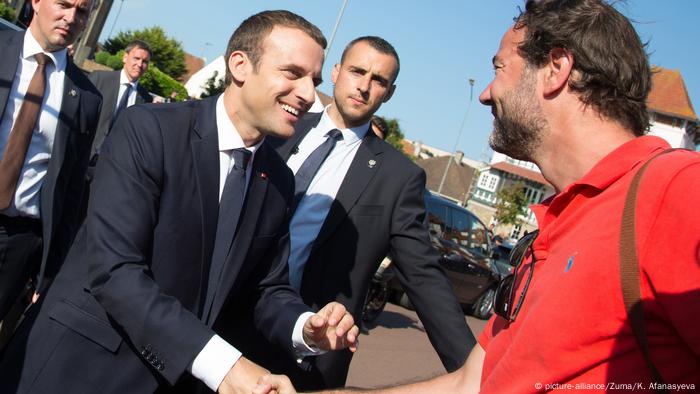 Emmanuel Macron shakes hands with a supporter of his party