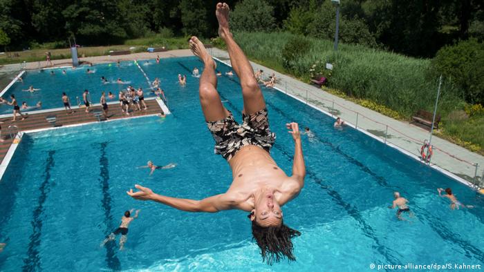 A boy jumping into a public pool (picture-alliance/dpa/S.Kahnert)