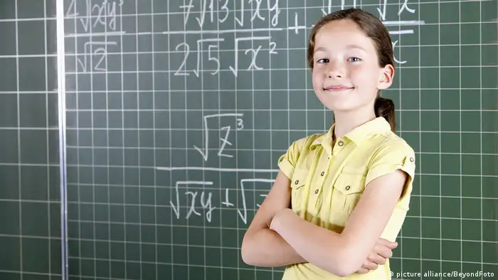 Ein Mädchen steht vor einer Schultafel mit Mathe-Formeln (picture alliance/BeyondFoto)