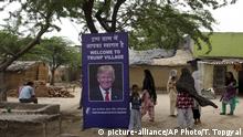 Indian village women stand next to a photograph of U.S. President Donald Trump displayed in Trump Sulabh Village, in Maroda, India, Friday, June 23, 2017. A toilet charity is leading an effort to rename a tiny, north Indian village after President Donald Trump, saying the gesture is meant to honor relations with the U.S. and draw support for better sanitation in India. (AP Photo/Tsering Topgyal) |