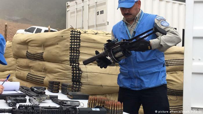 UN mission member holding weapon handed in by FARC