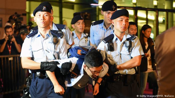 Hong Kong's youngest lawmaker Nathan Law is detained by police after he and other demonstrators staged a sit-in protest at the Golden Bauhinia statue in Hong Kong