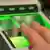 A person holds both thumps against an electronic fingerprint scanner