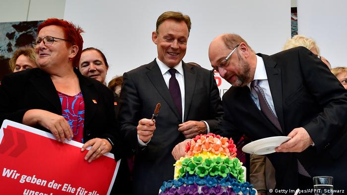 Leading Social Democrats Martin Schulz and Thomas Oppermann slice into a multicolored, multilayered cake after Friday's vote (Getty Images/AFP/T. Schwarz)