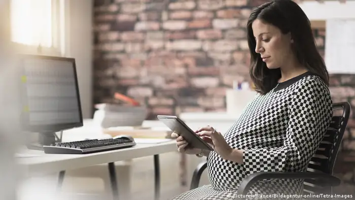 Pregnant woman working in office, Schwangere Frau, die im Büro arbeitet