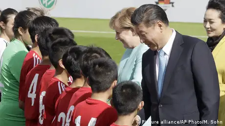 中国国务院2015年3月在中国国家主席习近平的指示下公布《中国足球改革总体方案》，提出中国足协与体育总局脱钩，加大对国家队投入，兴建两个训练基地，到2025年建成5万所足球特色学校等。当时有中国媒体以「中国足球春风拂面」、「习近平为足球改革注入最强执行力」为标题报导此消息。图为2015年习近平访问德国时，和时任德国总理默克尔在德国和中国12岁以下足球比赛前向球员致意。