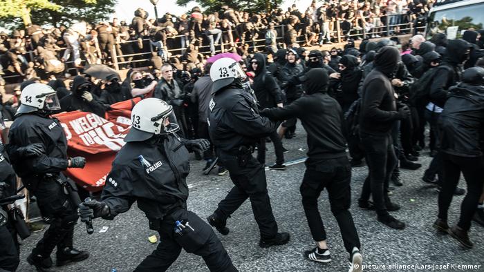 Police officers wearing numbers while arresting demonstrators
