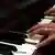 Close-up of hands playing a piano
