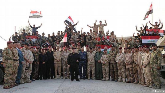 Irak, Der irakische Premierminister Haider al-Abadi hält eine irakische Flagge, als er den Sieg über den islamischen Staat in Mosul verkündet
