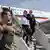 Президент ФРГ и его жена спускаются по трапу самолета в Мазари-Шарифе
