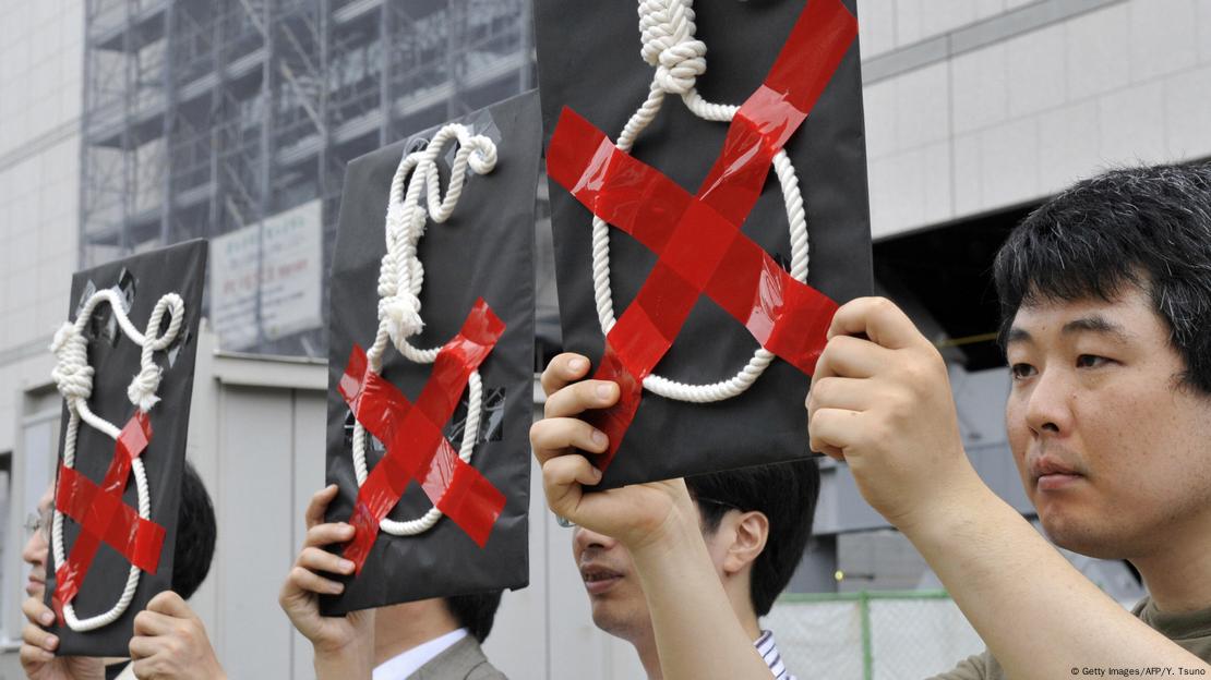 Japonya'da idam cezasına karşı düzenlenen protestolar esnasında, asılarak uygulanan bu cezayı ellerinde tuttukları yağlı urganın yapıştırılmış olduğu pankartları havaya kaldırarak tepki gösteren göstericiler.