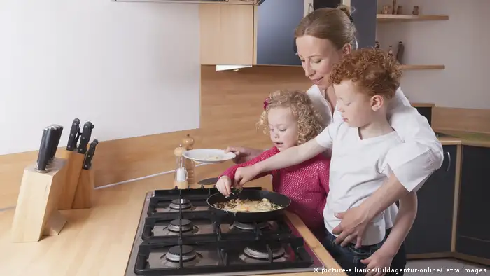 Mother, daughter (4-5) and son (8-9) preparing scrambled eggs together, Mutter und Kinder in der Kueche (picture-alliance/Bildagentur-online/Tetra Images)