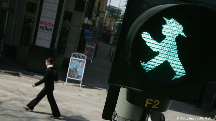 A woman walks past a pedestrian signal at a traffic intersection April 26, 2005 in Berlin, Germany (Getty Images/S. Gallup)