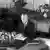 schwarz-weißes Bild: Konrad Adenauer sitzt am Schreibtisch und unterzeichnet das Grundgesetz (Foto: dpa)