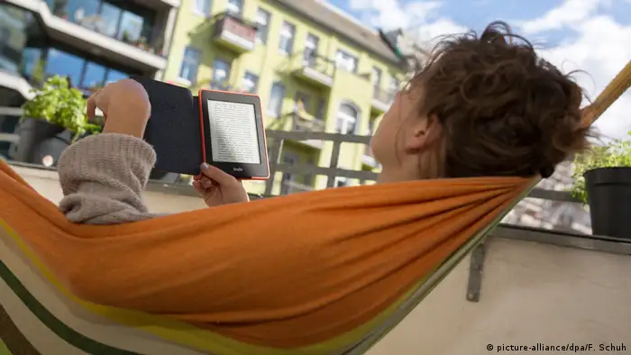 Frau mit E-Book-Reader auf dem Balkon (picture-alliance/dpa/F. Schuh)