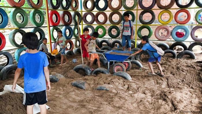 Çocuklar, duvarlar için renkli lastiklerle bir odada kumun taşınmasına yardımcı olur