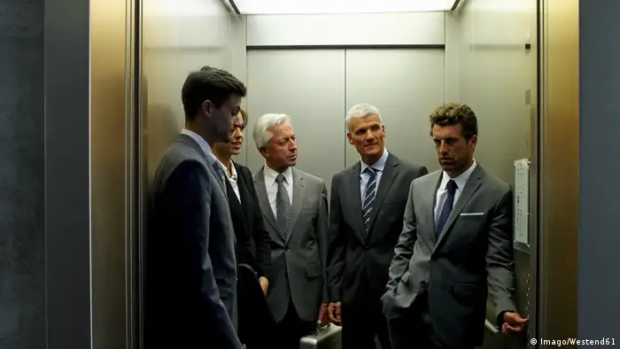 People in an office elevator (Imago/Westend61)
