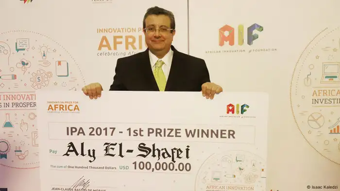 Aly El-Shafei smiles as he holds a giant cheque for $100,000