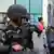 Dos soldados de la Guardia Nacional de México. Detrás una mujer.