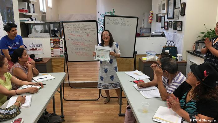 Phoolmaya Gurun shows her new citizenship certificate to her former class at the Nepali community center Adhikaar in New York