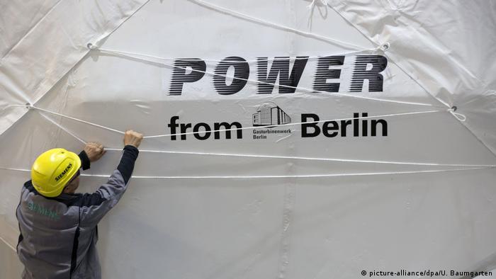 Рабочий Siemens зачехляет турбину на заводе в Берлине