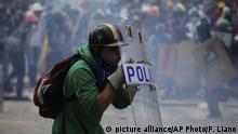 An anti-government protester protects himself with a police shield during clashes with security forces preventing a march to the Supreme Court opposing President Nicolas Maduro's plan to rewrite the constitution, in Caracas, Venezuela, Saturday, July 22, 2017. Venezuelan authorities have routinely responded with tear gas and rubber bullets to nearly four months of street protests, during which at least 97 people have died in the unrest. (AP Photo/Fernando Llano) |