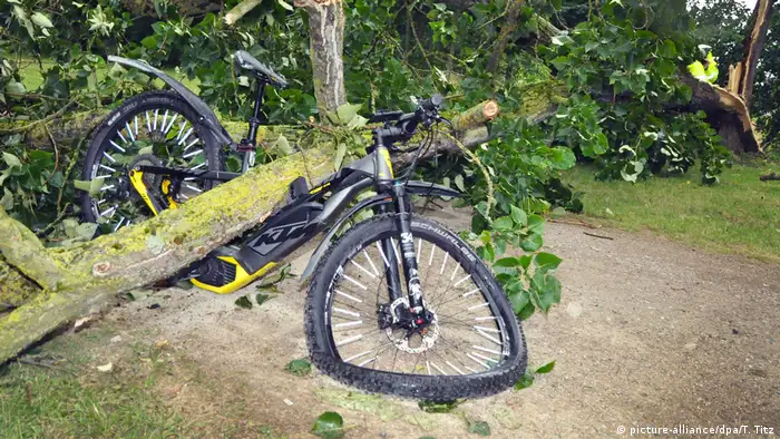 Ein Baum liegt in Mönchengladbach (Nordrhein-Westfalen) auf einem Fahrrad. Bei einem heftigen Gewitter stürzte der Baum um und begrub den Radfahrer unter sich. Der Mann wurde dabei verletzt und in ein Krankenhaus gebracht. (Foto: picture-alliance/dpa/T. Titz)