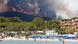 Flames and smoke fill the sky above a burning hillside as tourists swim on the beach in Bormes-les-Mimosas, in the Var department, France, July 26, 2017 Flames and smoke fill the sky above a burning hillside as tourists swim on the beach in Bormes-les-Mimosas, in the Var department, France, July 26, 2017