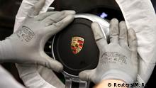 FILE PHOTO: A worker assembles a steering wheel of a new Porsche 911 sports car at the Porsche factory in Stuttgart-Zuffenhausen, March 10, 2015. REUTERS/Michaela Rehle TPX IMAGES OF THE DAY/File Photo