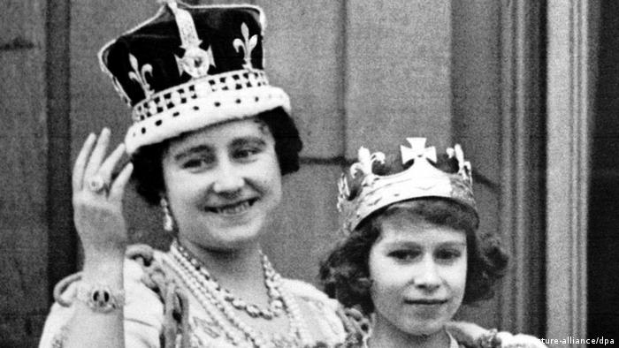 Ein Foto in Schwarz/Weiß (1937) zeigt die heutige Königin Elizabeth II. als junge Prinzessin neben ihrer Mutter, der Queen Mum, die die Krone mit den Kronjuwelen trägt