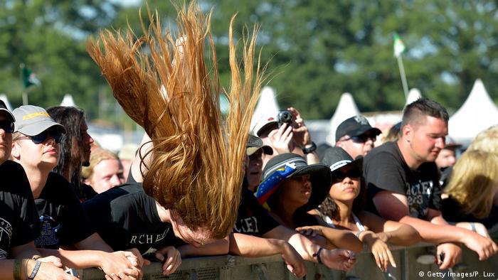 Ein Mann mit langen Haaren headbangt in einer Menschenmenge. (Foto: Getty Images/P. Lux)