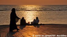 Saudi families spend an evening by a seafront promenade as the sun sets in the Red Sea city of Jeddah on July 7, 2011. AFP PHOTO/FAYEZ NURELDINE (Photo credit should read FAYEZ NURELDINE/AFP/Getty Images)