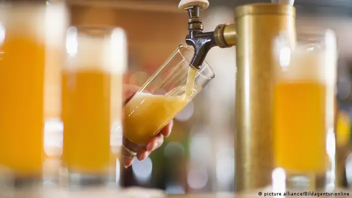 Barman poring beer from beer tap (picture alliance/Bildagentur-online)