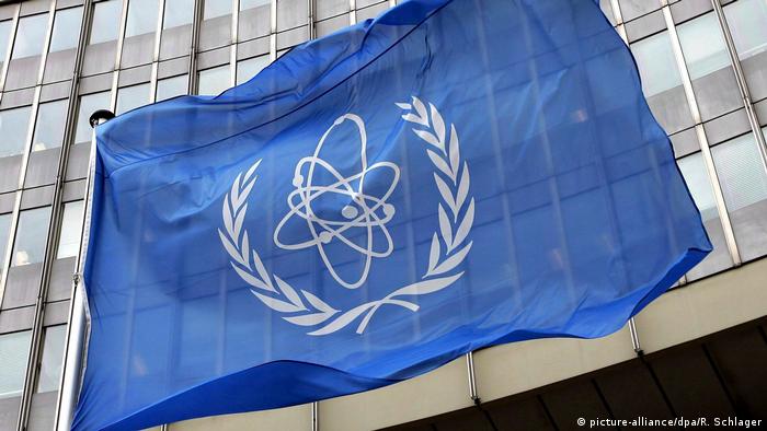 A flag bearing the symbol of the International Atomic Energy Agency IAEA waves outside the UN building in Vienna