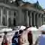 Touristen mit Sonnenschirmen vor dem Reichstag (Foto: Picture Alliance)