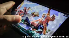 A Chinese mobile game player plays Tencent's mobile MOBA King of Glory or Honor of Kings on his smartphone in Beijing, China, 11 July 2017. All-night gaming marathons will soon end for some Chinese kids after internet giant Tencent began limiting daily playing times on its smartphone smash hit King of Glory to ensure children's healthy development. Young players will be restricted to one or two hours on the mobile online multiplayer battle game, which boasts 80 million daily users, as concerns grow in China that long periods online are posing a serious threat to the health of the country's youth. Users under 12 years old are now limited to one hour of play a day, and will not be permitted to sign in after 9 pm, Tencent said in a statement over the weekend. The move went into effect on Tuesday. Users between 12 and 18 years old are limited to two hours per day. Foto: Niu Bo/Imaginechina/dpa |