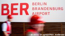 People wearing hard hats walk past a sign reading the name of the Berlin-Brandenburg International airport aka Willy Brandt Airport in the check in hall during a visit to the building site in Schoenefeld, near Berlin, on September 11, 2012, during the International Air Show ILA taking place nearby. For the fourth time in two years, the opening of the aiport to replace the German capital's two current hubs was put back in September 2012 to October 27, 2013.
AFP PHOTO / ODD ANDERSEN (Photo credit should read ODD ANDERSEN/AFP/GettyImages)