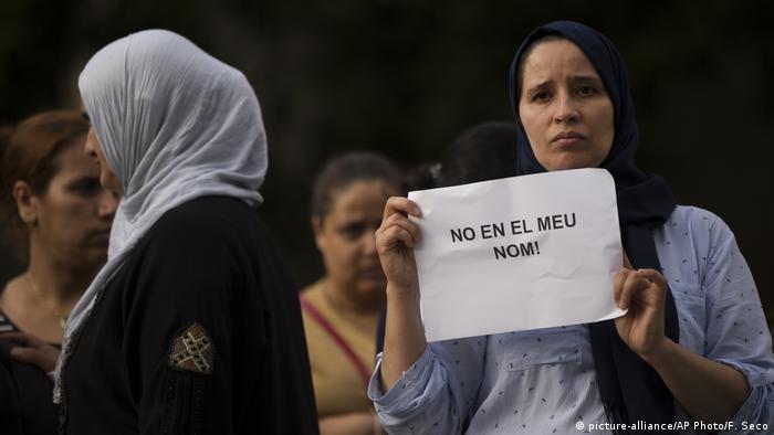A Muslim woman holds a sign that says 'Not in my name' at a demonstration against terrorism in Ripoll, outside Barcelona